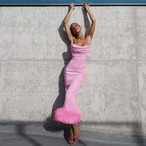 Detailed view of pink strapless long dress with luxurious satin finish and feather hem