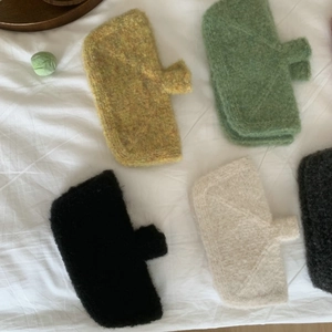 Flat lay of colorful knit pouches in yellow green black beige and dark grey colors
