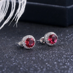 Macro shot of red round cut gemstone earrings with a halo of white cubic zirconia