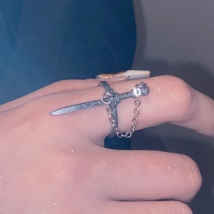 Macro-opname van een gotische zwaardring met zilveren ketting in punk-esthetiek