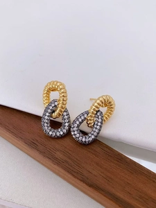 Detailed close-up of double-layer interlocking gold earrings with grey zircon inlay