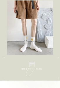 Close-up of white cotton socks with yellow smile print and smile text embroidery