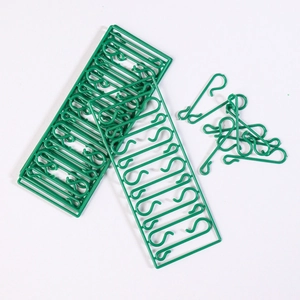 Close-up of green plastic S-shaped ornament hooks for hanging Christmas tree decorations