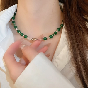 Détail du collier de perles en verre vert émeraude sur mannequin avec perles d'espacement