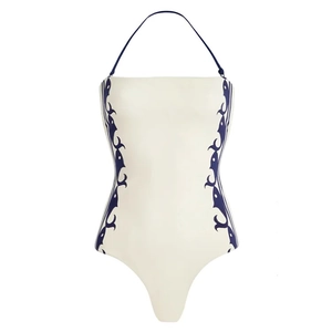 White halter one-piece swimsuit with blue tribal patterns and high cut design