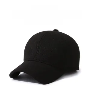 Close-up of black winter baseball cap with thick wool texture and side metal emblem