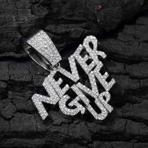 Macro shot of silver hip hop pendant with NEVER GIVE UP engraving and shining crystals