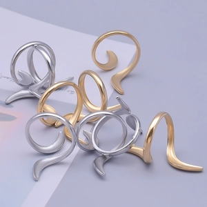 Detailed view of stackable spiral streamline rings in polished gold and silver finishes