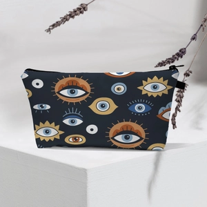 Macro view of blue travel toiletry bag with evil eye patterns on white geometric stand
