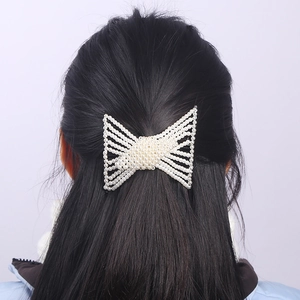 Elegant butterfly shaped pearl hair comb woven with white beads for a stylish bun hairstyle