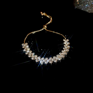 Detailed view of adjustable golden bracelet with shimmering cubic zirconia stars and flowers