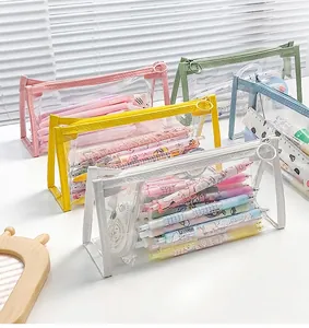 Close-up of colorful transparent PVC pencil cases with large ring zipper pulls and stationery
