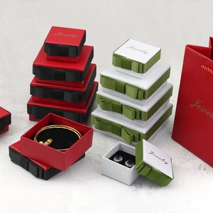 Dark green and red jewelry boxes with ribbon bows for rings, necklaces, and bracelets