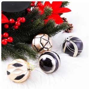 Detailed view of 6cm black and gold painted Christmas balls on white faux fur background