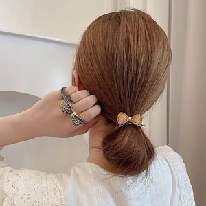 Elegant crystal bow hair tie and clip set featuring sparkling rhinestones on a ponytail