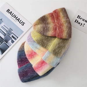 Flat lay of gradient tie-dye knitted beanies in various warm colors for winter