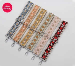 Close-up of bohemian geometric woven bag straps with silver metal clasps and chains