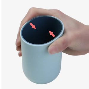 Flexible light blue mouthwash cup made of soft plastic showing compression feature