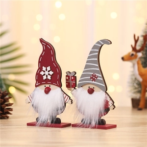 Détail de gnomes de Noël en bois avec bonnet rouge à flocons et bonnet gris rayé