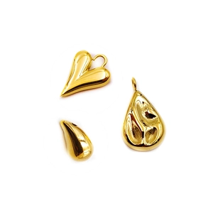 Macro shot of 18K gold-plated heart and water-drop shaped charms with textured finish