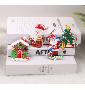 Detail of polymer clay Christmas ornaments featuring Santa and Gingerbread House on white rug