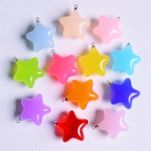 Close-up of colorful 16mm star-shaped resin charms with metal loops on white background