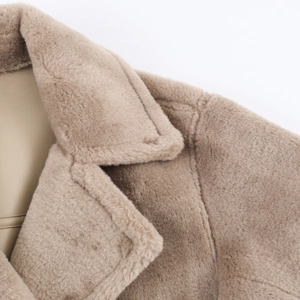 Close-up of khaki faux lamb wool coat showing soft texture and premium stitching detail