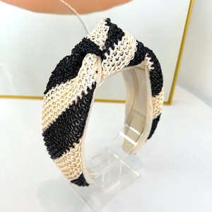 Vue détaillée du serre-tête en paille tressée avec un design noué noir et beige élégant