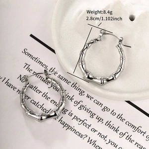 Dettaglio di orecchini a cerchio in argento stile bambù su piatto, diametro di 2,8 cm