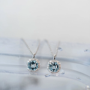 Macro detail of aquamarine square halo pendants on S925 sterling silver necklaces