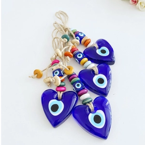 Close-up of heart-shaped glass Evil Eye charms with colorful beads and hemp rope