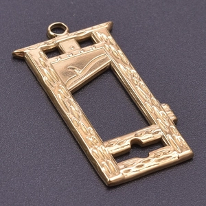 Detail shot of a creative golden guillotine pendant with mechanical frame design