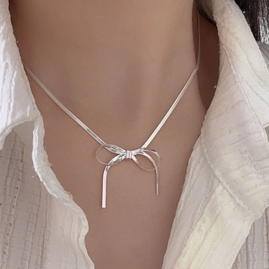 Elegant s925 sterling silver bow necklace with a flat snake chain on model neck