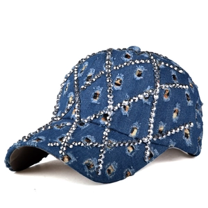 Dettaglio del cappello di jeans blu con strass scintillanti e finitura usurata