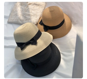Detailed weave of sun hats in cream, camel, and black with elegant black bow ribbons
