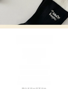 Detail of Bébé Bonjour letter embroidery on black and white cotton crew socks