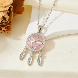 Collier attrape-rêves argenté avec pierre rose et plumes sur présentoir