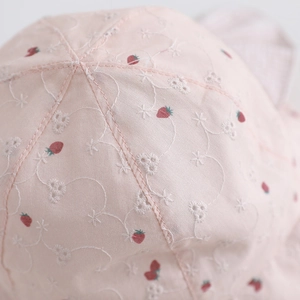 Détail du chapeau rose pour fille avec motifs de fraises et broderies florales fines