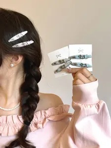 Close-up of pink and blue resin hair clips with rhinestone dog motif on display card