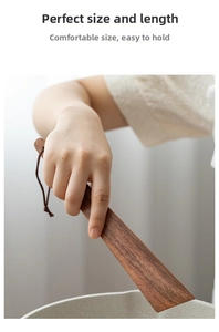 Détail d'une spatule en bois d'acacia avec grain naturel et lanière de suspension en cuir
