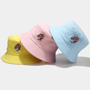 Trois bobs en coton colorés avec broderie de champignons en jaune, rose et bleu