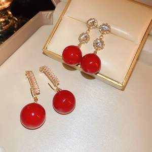 Elegant red pearl drop earrings with gold zircon accents in a luxury jewelry box