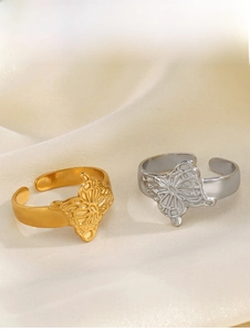 Close-up of gold and silver butterfly open rings on elegant beige satin fabric