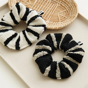 Detail of tweed striped hair scrunchies in black and white with woven texture