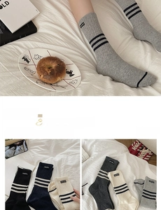 Detail of ribbed cotton striped socks with cloth label and three-stripe athletic cuff