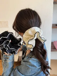 Detail of black and white polka dot scrunchie with multi-layered pleated edges decoration