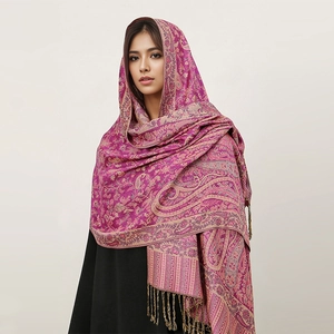 Detail of luxury paisley pashmina shawl with fringes in purple and gold colors