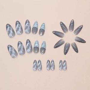 Detail of almond nails with blue wave tips, marble texture, and sparkling rhinestones