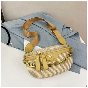 Detail of straw waist bag featuring yellow trim and decorative gold chain ornament