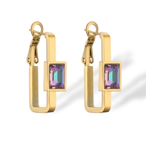Macro shot of gold geometric hoop earrings with iridescent rectangular zircon stones